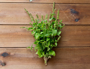 Image showing close up of fresh melissa bunch on wooden table