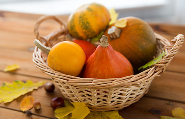 Image showing close up of pumpkins in basket on wooden table