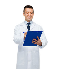 Image showing smiling male doctor with clipboard writing