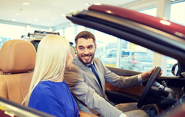 Image showing happy couple buying car in auto show or salon