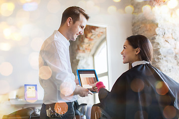 Image showing happy woman and stylist with tablet pc at salon