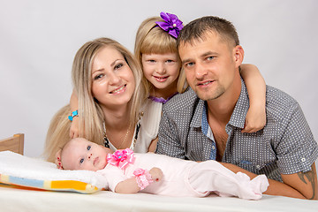 Image showing Mother, father, daughter and five-year newborn baby looks in the picture