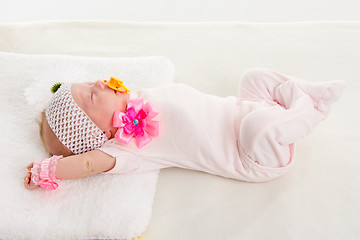 Image showing Baby girl stretches in his sleep lying in bed