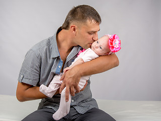 Image showing Happy dad kisses his infant daughter two months