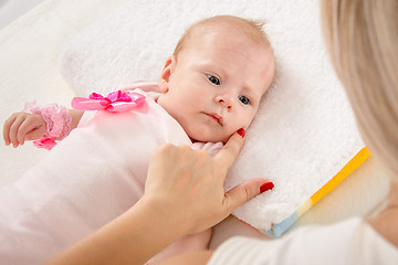 Image showing Mom leaned her finger to her cheek two-month girl