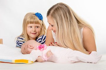 Image showing The five-year girl is looking at her mother who is looking at newborn daughter