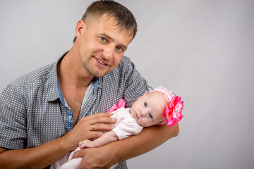 Image showing Happy dad is holding a two-month girl