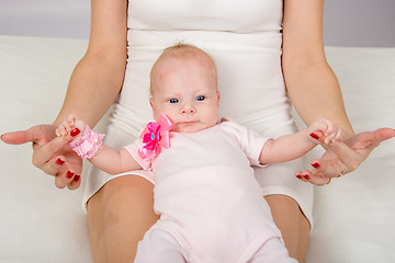 Image showing Mom put a two-month baby on her knees and holding his pen