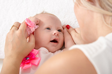 Image showing Mom took the handles of the baby girl and put it to her head