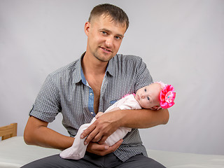 Image showing Joyful father holding newborn daughter