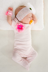 Image showing The two-month girl sleeps on the bed at the head outstretched hands