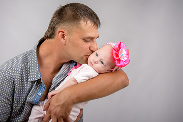 Image showing Happy dad kissing a two-month baby daughter