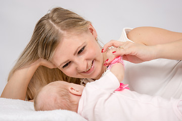 Image showing Mom is near a two-month baby and lovingly looks at him