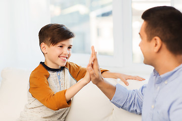 Image showing happy father and son doing high five at home