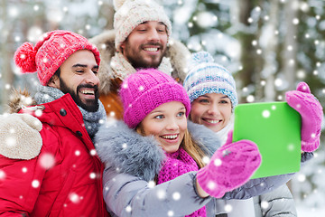 Image showing smiling friends with tablet pc in winter forest