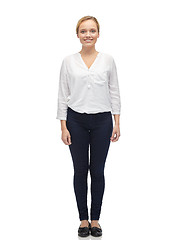 Image showing smiling young woman in white shirt and jeans