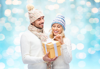 Image showing smiling couple in winter clothes with gift box