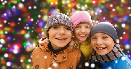 Image showing happy children over snow and christmas lights