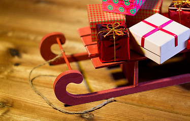Image showing close up of christmas gift boxes on wooden sleigh