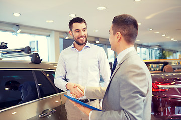 Image showing happy man shaking hands in auto show or salon
