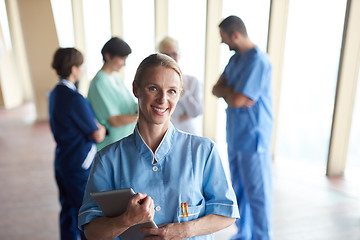 Image showing female doctor with tablet computer  standing in front of team