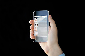 Image showing close up of male hand with transparent smartphone