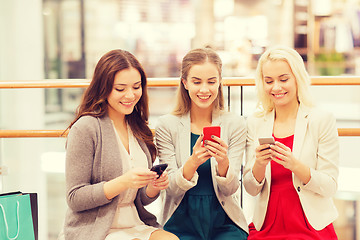 Image showing happy women with smartphones and shopping bags