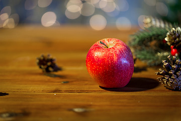 Image showing close up of apple with fir decoration on wood