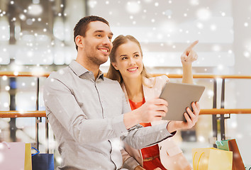 Image showing couple with tablet pc and shopping bags in mall