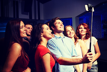 Image showing friends with smartphone taking selfie in club