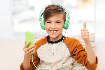 Image showing happy boy with smartphone and headphones at home