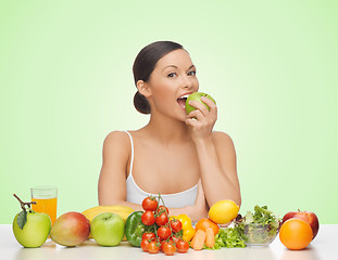 Image showing woman with fruits and vegetables eating apple