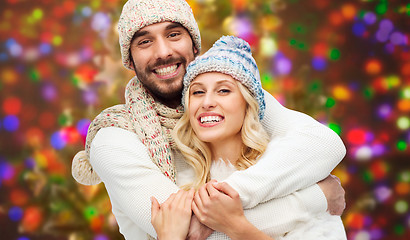 Image showing happy couple in winter clothes hugging over lights