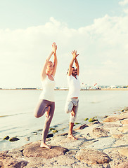 Image showing couple making yoga exercises outdoors