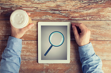 Image showing close up of male hands with magnifier on tablet pc