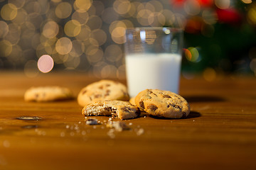 Image showing close up of cookies and milk over christmas lights