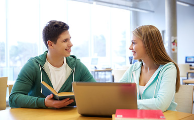 Image showing happy students with laptop and books at library