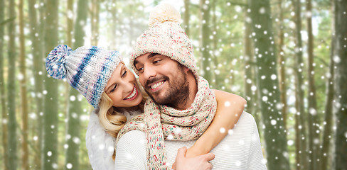 Image showing happy couple in winter clothes hugging over forest