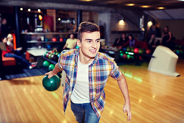 Image showing happy young man throwing ball in bowling club