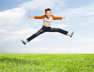 Image showing happy smiling boy jumping in air