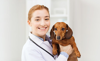 Image showing happy doctor with dog at vet clinic