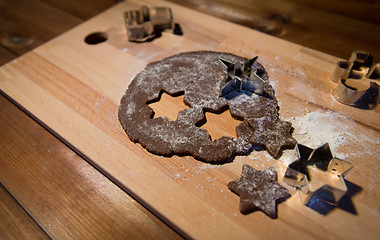 Image showing close up of ginger dough, molds and flour on board