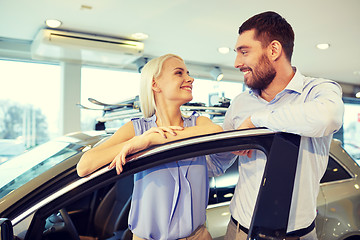 Image showing happy couple buying car in auto show or salon