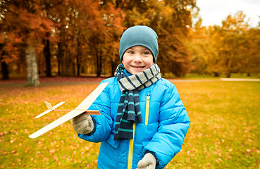 Image showing happy little boy playing with toy plane outdoors