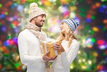 Image showing smiling couple in winter clothes with gift box