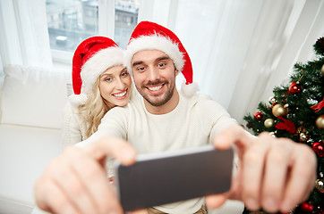 Image showing couple taking selfie with smartphone at christmas