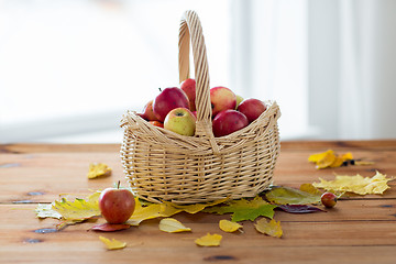 Image showing close up of basket with apples on wooden table