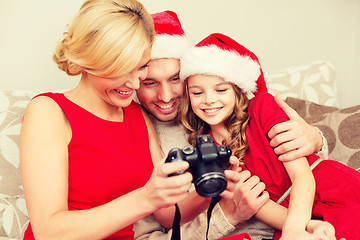 Image showing family in santa helper hats looking at pictires