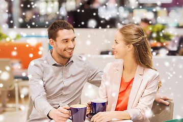 Image showing happy couple with shopping bags drinking coffee