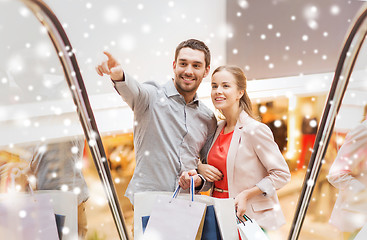 Image showing couple with shopping bags on escalator in mall